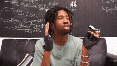 A Man Is Sitting On A Couch In Front Of A Blackboard That Says Biz Model On It GIF