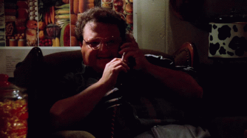 A Man Is Sitting On A Couch Talking On A Cell Phone And The Words Excellent Are On The Bottom GIF