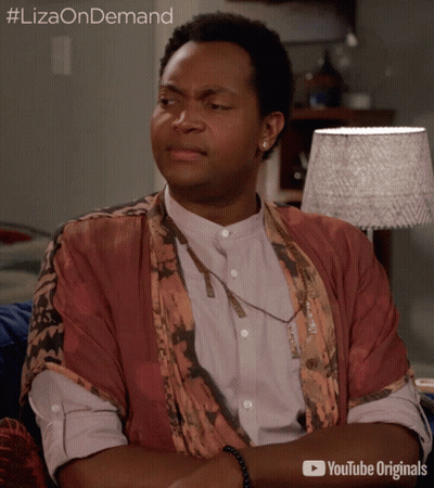 A Man Is Sitting On A Couch With His Arms Crossed And A Youtube Originals Advertisement Behind Him GIF