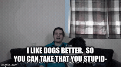 A Man Is Sitting On A Couch With His Dog And Says I Like Dogs Better So You Can Take That You Stupid GIF