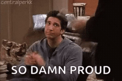 A Man Is Sitting On A Couch With His Hands Folded And The Words `` So Damn Proud '' . GIF