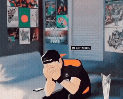A Man Is Sitting On A Couch With His Head In His Hands In Front Of A Wall With Posters On It . GIF