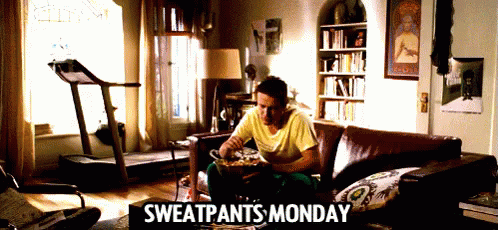 A Man Is Sitting On A Couch With Sweatpants Monday Written On It GIF