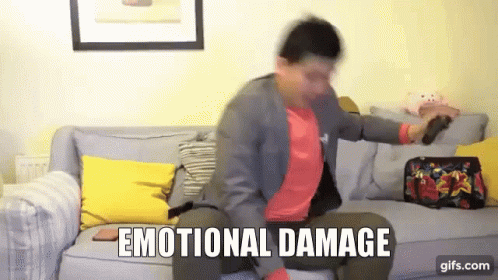 A Man Is Sitting On A Couch With The Words Emotional Damage Written On The Screen GIF