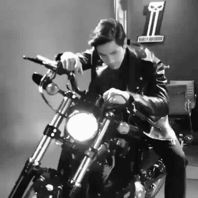 A Man Is Sitting On A Harley Davidson Motorcycle In A Black And White Photo . GIF