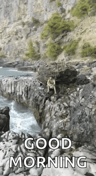 A Man Is Sitting On A Rock Overlooking The Ocean With A Good Morning Message . GIF