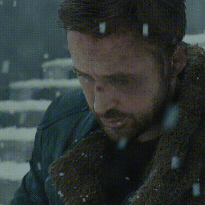 A Man Is Sitting On A Set Of Stairs In The Snow Looking At His Phone GIF