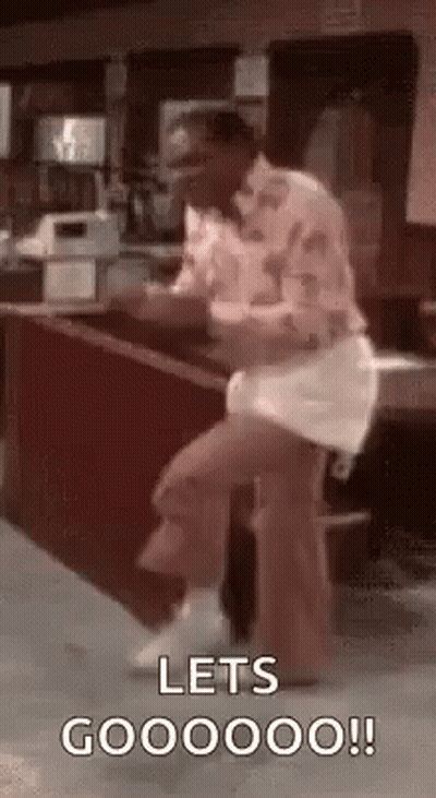 A Man Is Sitting On A Stool In Front Of A Counter And Dancing . GIF