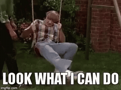 A Man Is Sitting On A Swing With The Words `` Look What I Can Do '' Written Below Him . GIF