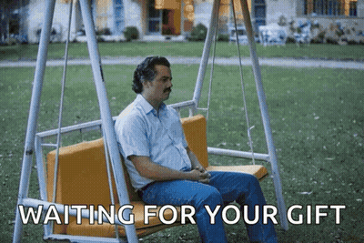 A Man Is Sitting On A Swing With The Words " Waiting For Your Gift " Below Him GIF