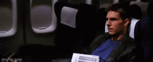A Man Is Sitting On An Airplane Reading A Newspaper That Says " Travel " GIF