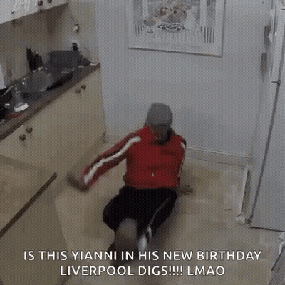 A Man Is Sitting On The Floor In A Kitchen And Dancing . GIF
