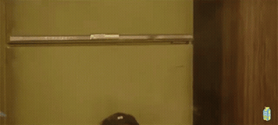 A Man Is Sitting On The Floor Smoking A Cigarette While Wearing A Hat And Glasses . GIF