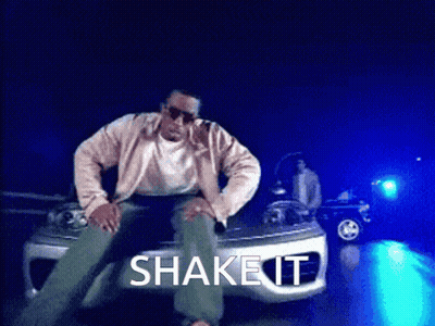A Man Is Sitting On The Hood Of A Car With The Words Shake It Written Above Him GIF