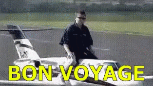A Man Is Sitting On The Wing Of An Airplane With The Words Bon Voyage Written On It GIF