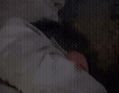 A Man Is Sleeping In A Bed With His Head On A Pillow And His Eyes Closed . GIF