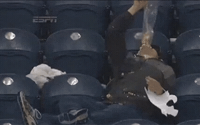 A Man Is Sleeping In A Stadium With Espn On The Seat GIF