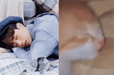 A Man Is Sleeping On A Bed Next To A Picture Of A Cat GIF