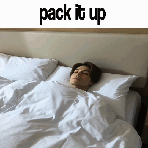 A Man Is Sleeping On A Bed Under A Sign That Says Pack It Up GIF
