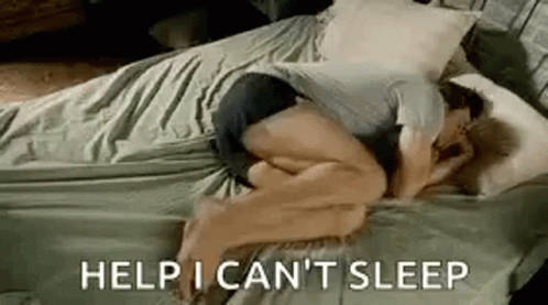 A Man Is Sleeping On A Bed With The Words `` Help I Can 'T Sleep '' Written On The Bottom . GIF