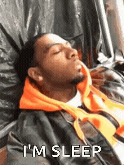 A Man Is Sleeping On A Bed With The Words `` I 'M Sleep '' Written Next To Him . GIF