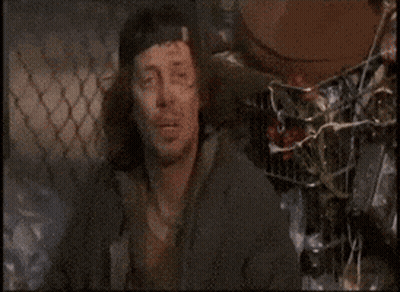 A Man Is Sleeping On A Pile Of Cans GIF
