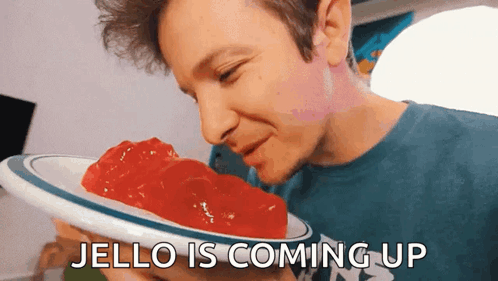 A Man Is Smelling A Plate Of Jello With The Words Jello Is Coming Up Below Him GIF
