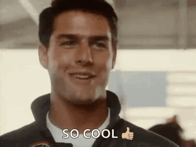 A Man Is Smiling And Giving A Thumbs Up While Wearing A Jacket And A White Shirt . GIF