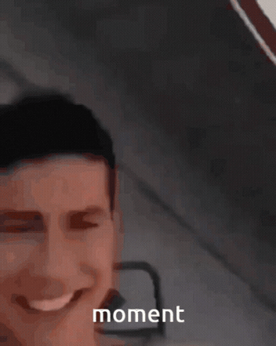 A Man Is Smiling And Holding A Yellow Object In Front Of Him With The Word Moment Visible GIF