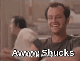 A Man Is Smiling And Laughing With The Words `` Aww Shucks '' Written On The Screen . GIF