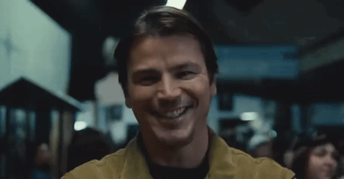 A Man Is Smiling And Looking At The Camera In A Blurry Photo . GIF