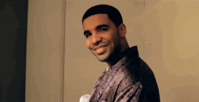 A Man Is Smiling And Looking At The Camera While Wearing A Robe . GIF