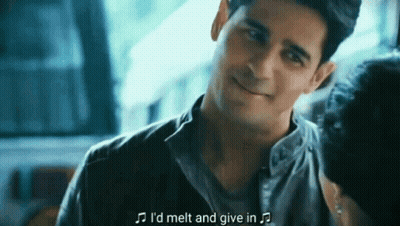 A Man Is Smiling And Talking To A Woman While Holding A Microphone . GIF
