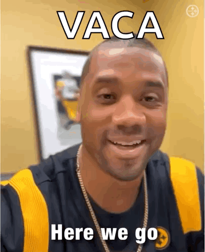 A Man Is Smiling And Wearing A Black And Yellow Shirt With The Words Vaca Here We Go Written On It . GIF