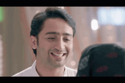 A Man Is Smiling At A Woman In A Black Hijab . GIF