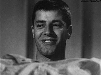 A Man Is Smiling In A Black And White Photo With Colonycharcoal Written Below Him GIF