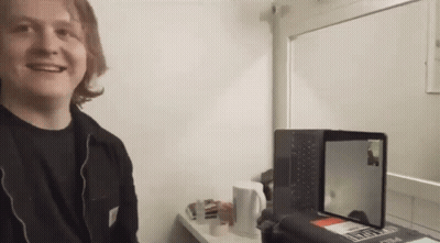 A Man Is Smiling In Front Of A Laptop That Says ' Sydney ' On The Screen GIF