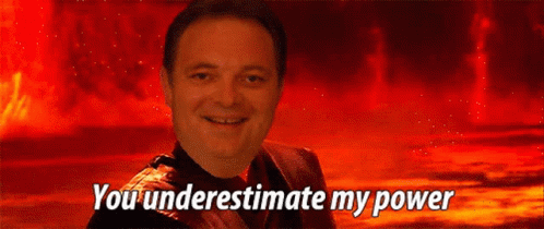 A Man Is Smiling In Front Of A Red Background With The Words You Underestimate My Power GIF