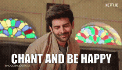 A Man Is Smiling In Front Of A Stained Glass Window And Says Chant And Be Happy GIF