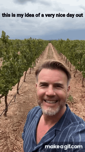 A Man Is Smiling In Front Of A Vineyard With The Words " This Is My Idea Of A Very Nice Day Out " Above Him GIF