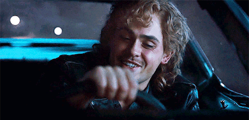 A Man Is Smiling While Driving A Car At Night . GIF