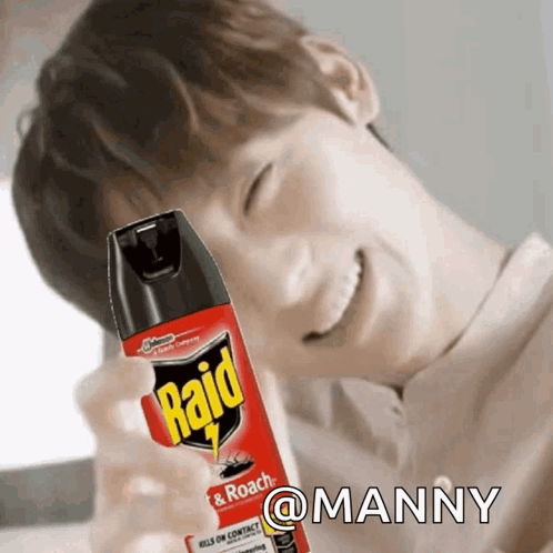 A Man Is Smiling While Holding A Raid Insect Spray GIF