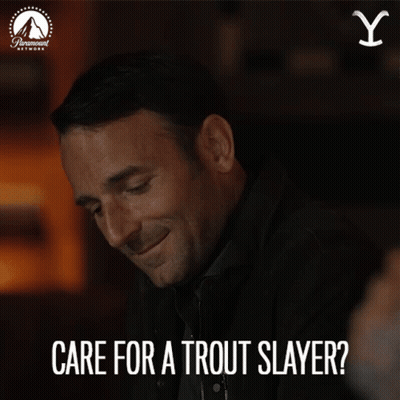 A Man Is Smiling With The Words Care For A Trout Slayer Above Him GIF