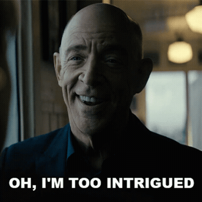 A Man Is Smiling With The Words Oh I 'M Too Intrigued Behind Him GIF