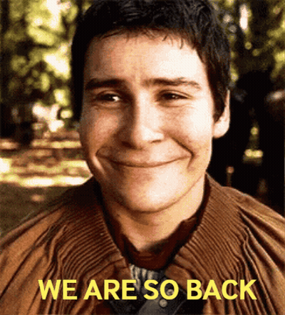 A Man Is Smiling With The Words We Are So Back Above Him GIF