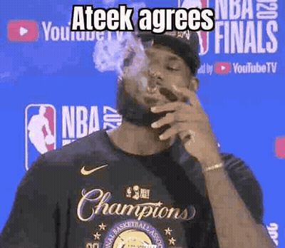 A Man Is Smoking A Cigarette In Front Of A Basketball Player Wearing A Championship Shirt . GIF