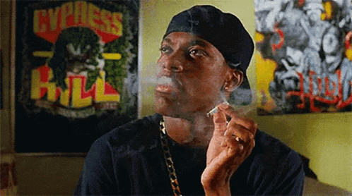 A Man Is Smoking A Cigarette In Front Of A Poster That Says Express Hill GIF