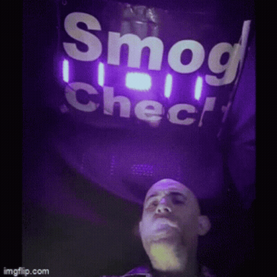 A Man Is Smoking A Cigarette Under A Sign That Says Smog Check GIF