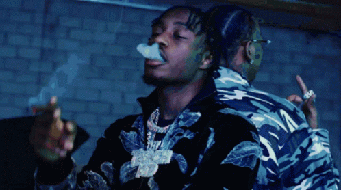 A Man Is Smoking A Cigarette While Another Man Looks On GIF