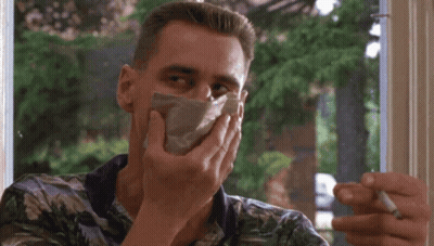 A Man Is Smoking A Cigarette While Covering His Mouth With A Napkin GIF